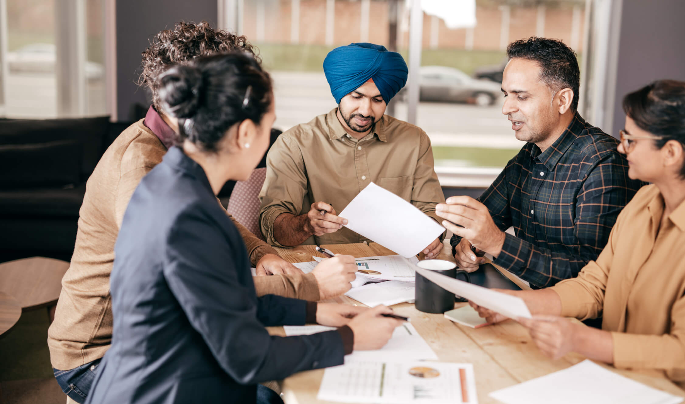 Multicultural group of people sitting around a conference table